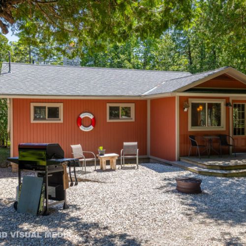 Front view of the cottage with plenty of space to unwind outdoors, complete with BBQ and seating.