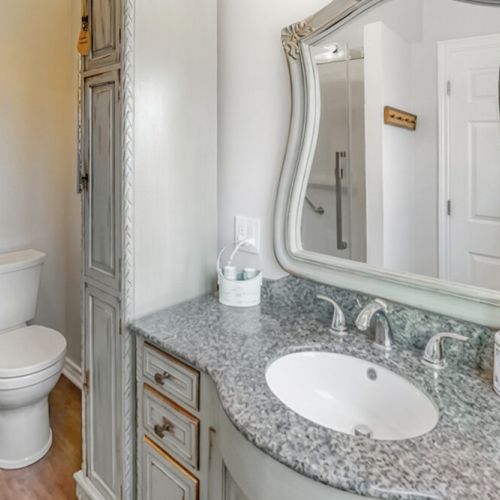 A bright, well-appointed bathroom with stone counters and storage. Designed for comfort and convenience during your cottage vacation.