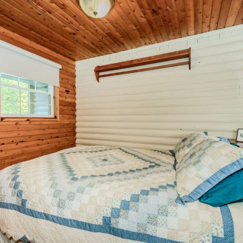 Drift off in this inviting bedroom, featuring a handcrafted quilt, natural wood accents, and peaceful vibes—perfect for restful nights during your family getaway or nature-filled retreat.
