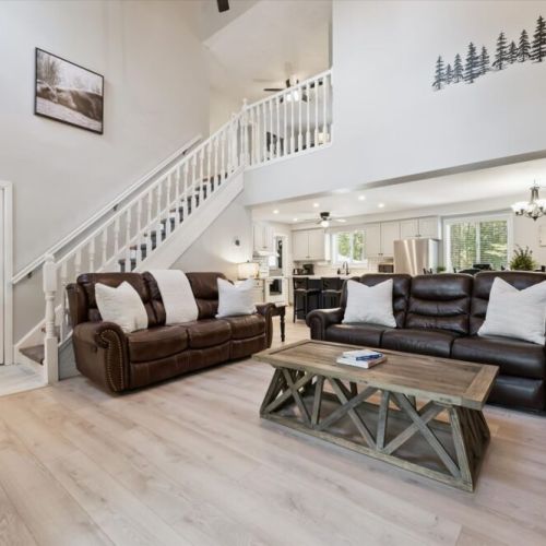 Open-concept living space with comfortable furnishings and plenty of natural light throughout the cottage.