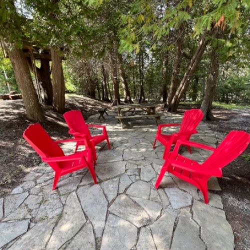 Surrounded by towering cedars, the outdoor fire pit is a guest favorite. Relax in bright red Adirondack chairs, share stories, and enjoy peaceful evenings under the stars.