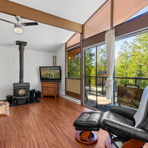 Unwind beside the wood stove or step out onto the spacious deck to enjoy the peaceful woodland setting.