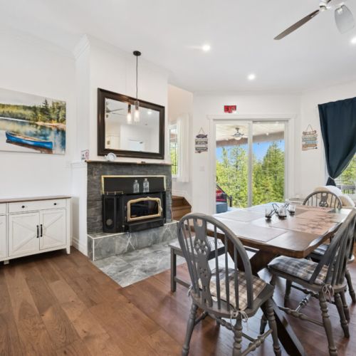 Enjoy meals together beside the cozy fireplace, with easy access to the outdoor deck and lake views.