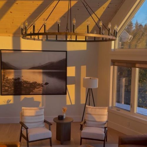 Warm leather seating, soft designer lighting, and curated décor create an inviting space to unwind by the fire after a day outdoors.