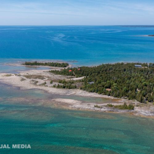 Aerial view of Georgian Bay’s incredible turquoise shoreline—your Tobermory playground right outside the trees.