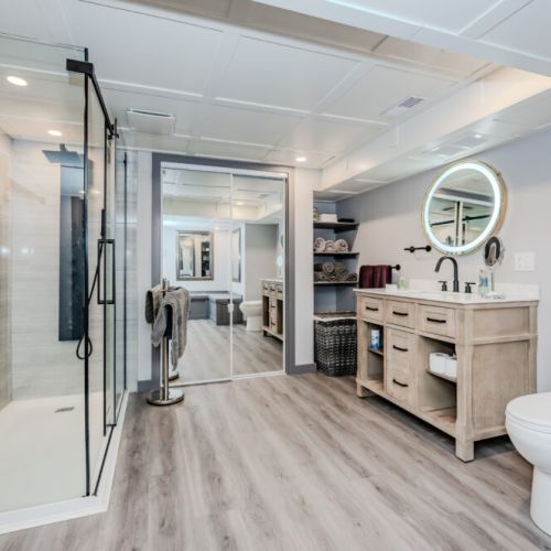 Luxurious spa-style bathroom with glass shower, modern vanity, and warm finishes. A relaxing retreat after a day of lakeside adventure, perfect for rejuvenating during your vacation.