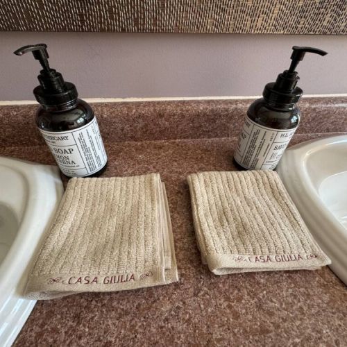 Thoughtfully stocked dual sinks with luxury soaps and Casa Giulia towels for a cozy, boutique stay.