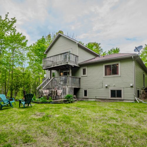 The expansive backyard offers a well-maintained lawn and a versatile deck space, making it an excellent spot for barbecues, picnics, and outdoor fun.