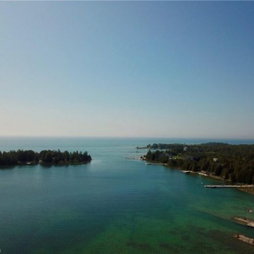 Take in sweeping aerial views of Lake Huron’s turquoise waters and the peaceful Little Pine Tree Harbour setting.