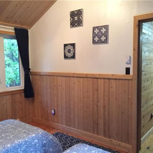 Bedroom 2: Comfortable bedroom with natural wood finishes, creating a calm and restful atmosphere.