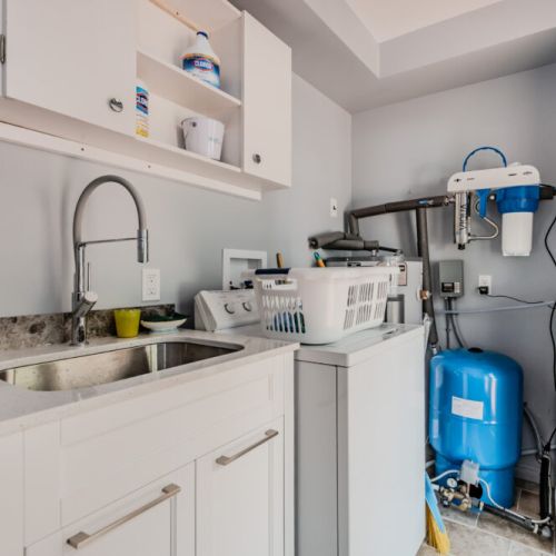 The functional laundry room is equipped with all necessary appliances and storage solutions, ensuring convenience during your stay at Beeshore.