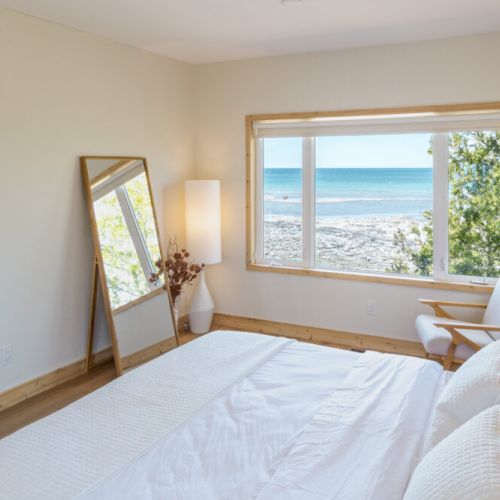 Indulge in the ultimate lakefront luxury with this spacious bedroom. The large windows offer stunning views of the lake, creating a truly unforgettable experience.