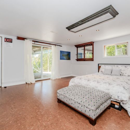 Sunlit guest suite with walk-out patio access, perfect for nature lovers and families. Enjoy peaceful mornings or unwind after lakeside adventures in this airy escape.