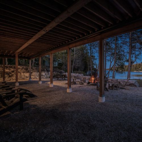Unwind lakeside at this cozy vacation rental, complete with a covered patio, Adirondack chairs, and a crackling fire pit—ideal for tranquil evenings, nature-filled getaways, and memorable cottage country experiences.