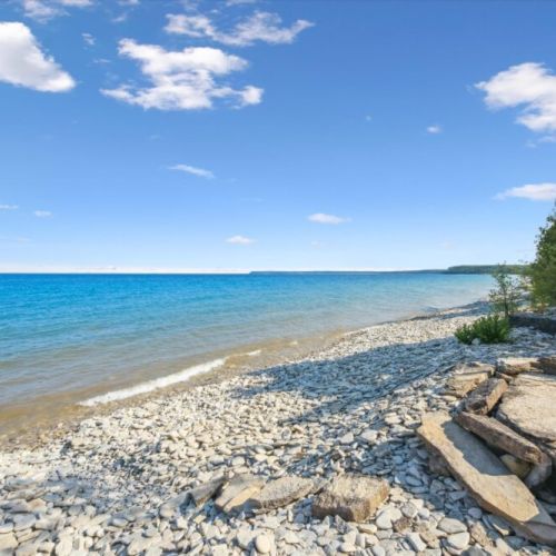 Another perspective of your private shoreline—clear water, rugged rocks, and peaceful seclusion at its finest.
