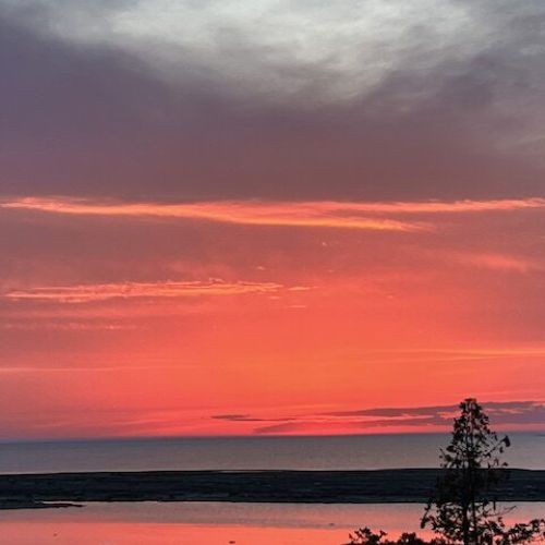 The view from the back of the property, the sun reflecting on the calm waters.