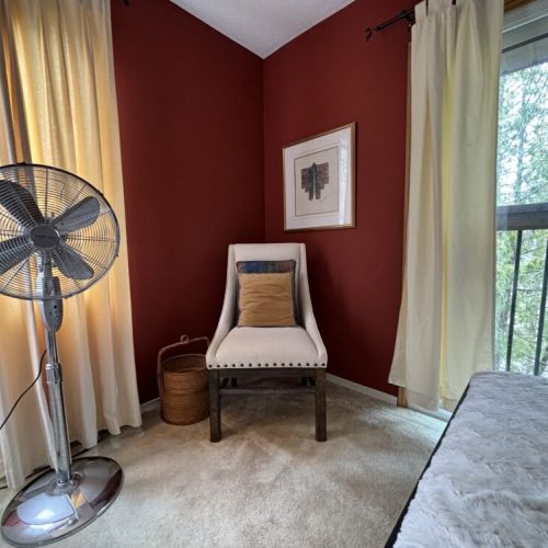 Relaxed Corner: Find solace in this serene corner of The Louise, where a comfortable armchair awaits by the window. It’s the perfect spot to unwind with a book or simply enjoy the gentle breeze from the fan while admiring the peaceful view of the lush surroundings.