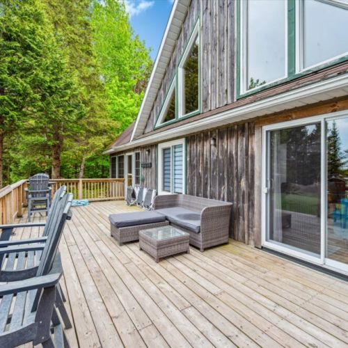 Unwind on the expansive lakeside deck—perfect for morning coffee, afternoon lounging, or sunset cocktails with views of the forest and waterline.