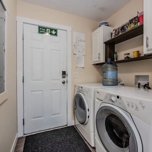 Fully equipped laundry area with a washer and dryer, located just off the kitchen, ensures you can keep your clothes fresh during your stay.