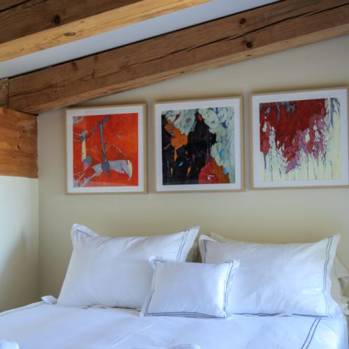 A cozy bedroom with exposed wood beams offers a peaceful place to unwind after a day of adventure.