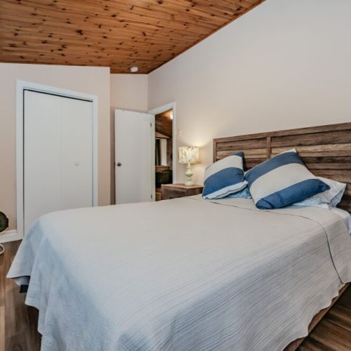 Another comfortable bedroom, thoughtfully furnished with a queen bed, rustic wooden accents, and modern touches, creating a warm, welcoming space for guests.