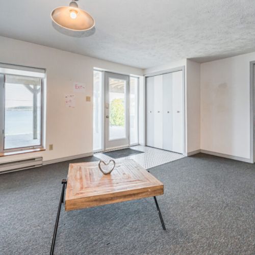 Bright and airy lounge area with modern furnishings and decor. This room provides direct access to the lakeside lower patio, making it an ideal spot for relaxation and soaking in the magnificent lake views.