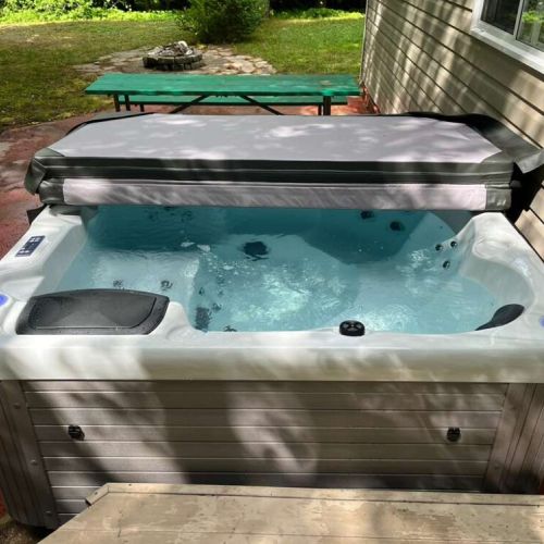 Private outdoor hot tub — unwind under the trees after a day at the beach