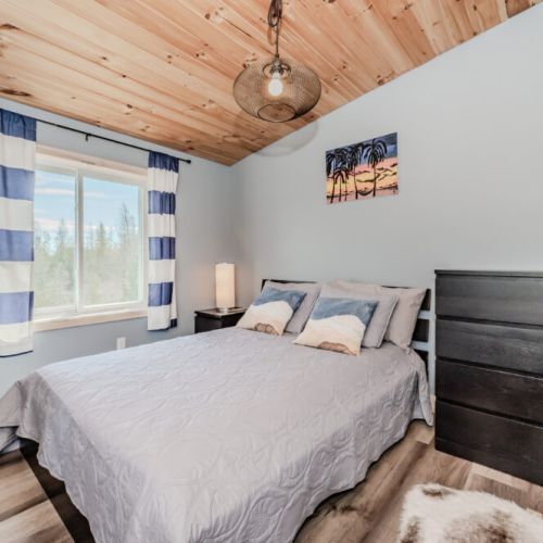 Relax in a stylish bedroom with a cozy cottage vibe, scenic views, and soft wood finishes—ideal for restful nights after days of discovery.