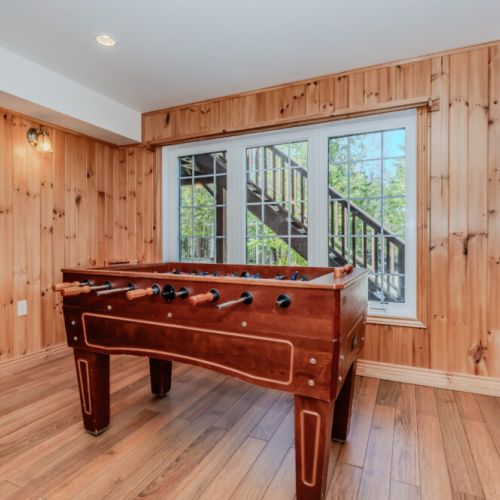 Rustic foosball nook with natural light and woodland views, perfect for indoor play on a relaxing getaway.