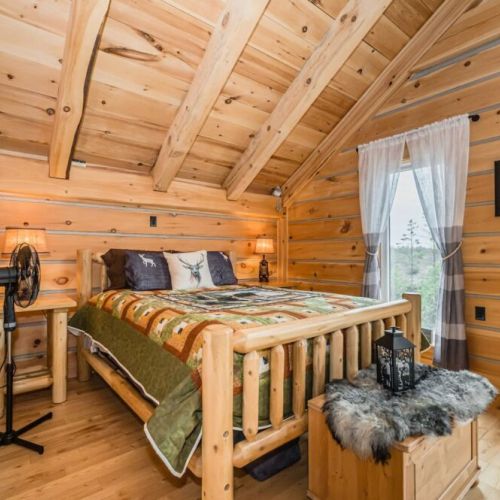 The loft bedroom not only offers a comfortable bed and rustic decor but also provides direct access to the balcony, inviting you to step outside and soak in the stunning natural surroundings.