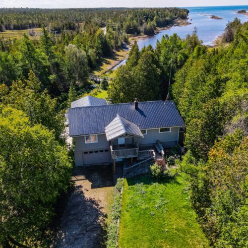 Explore the charm of this property, where a picturesque canal gracefully connects the main house to the tranquil lake, offering serene views and waterfront access.