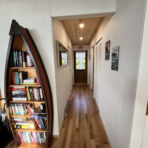 A charming hallway adorned with a unique boat-shaped bookshelf, adding character and providing a selection of reading materials for guests.