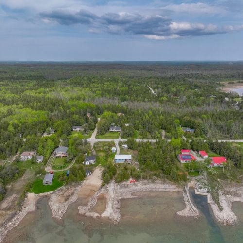 Aerial view of Len Cove and the quiet beauty of Howdenvale—Lake Huron’s sparkling shoreline and lush forest set the scene for a peaceful retreat.