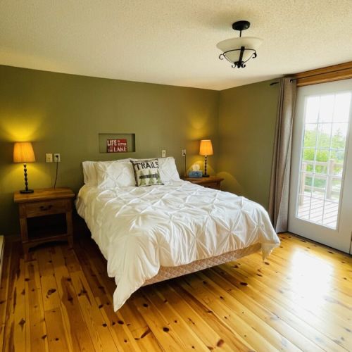Bedroom 1: Bright and comfortable queen bedroom with walkout to the deck