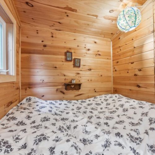 Retreat to this built-in pine sleeping alcove — a serene and snug space wrapped in warm woodgrain, perfect for afternoon naps or restful nights.