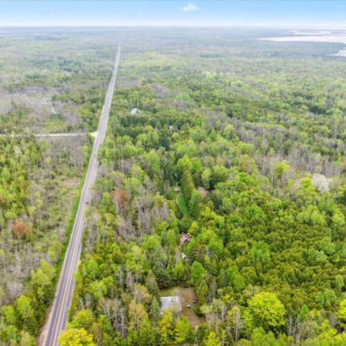 This aerial corridor shot puts Chief’s Cottage in context — one of just a few homes tucked into a stretch of green, with a long winding road threading through the forest. The approach alone sets the tone for an unplugged, restorative stay.