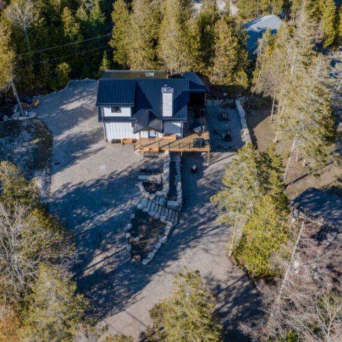 Aerial view of a secluded vacation rental nestled in the trees, steps from the lake. Perfect for nature getaways, family retreats, and waterfront escapes with easy access to outdoor adventures.