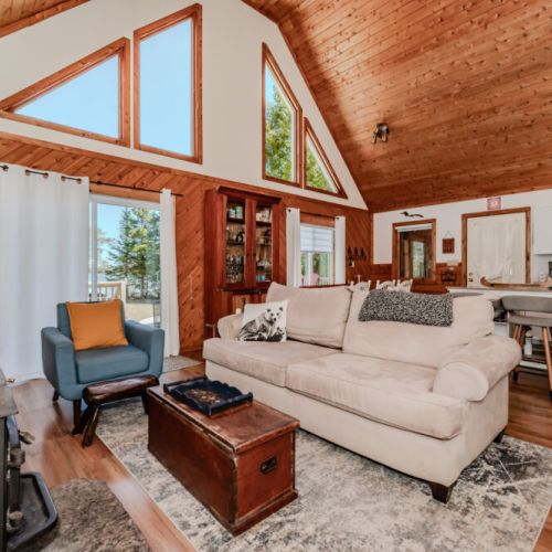 Bright open-concept living space with vaulted ceilings, stunning lake views, and easy access to outdoor adventures from this beautiful rental.