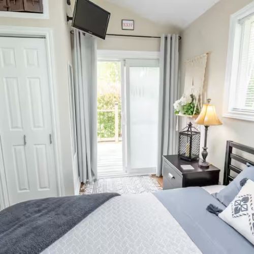 Another angle of the primary bedroom reveals its thoughtful details — sliding doors to the deck, a mounted TV for cozy nights in, and a bright, airy atmosphere that makes it the perfect retreat after a day of adventure.