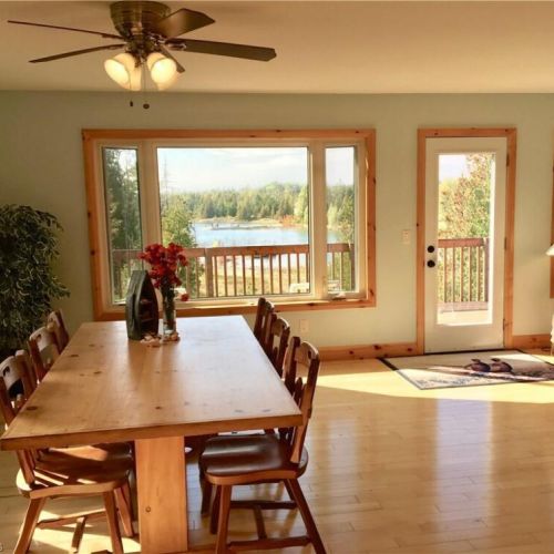 Gather around the dining table with beautiful lake views and direct access to the deck just steps away.