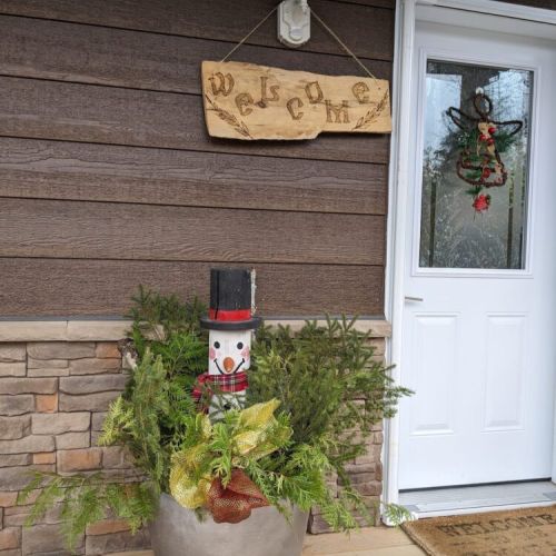 Step into the holiday spirit—charming front entrance with a snowman planter and seasonal greenery to greet your stay.