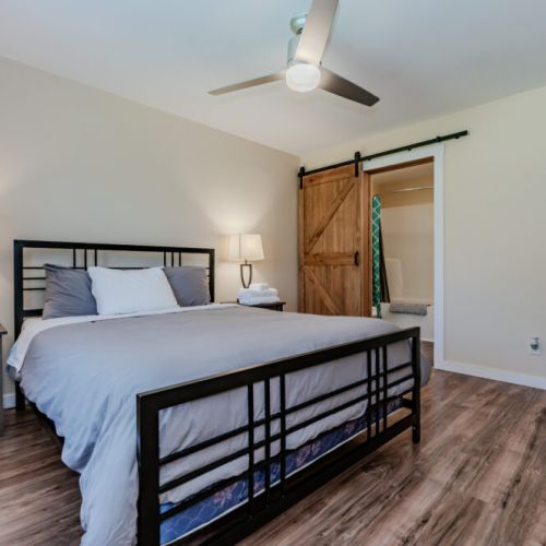 This bedroom offers a comfortable queen-sized bed and a stylish sliding barn door leading to the ensuite bathroom for added privacy.