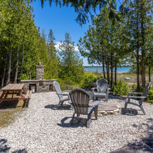 Lakeside firepit circle with plenty of seating—gather, relax, and watch the waves roll in.