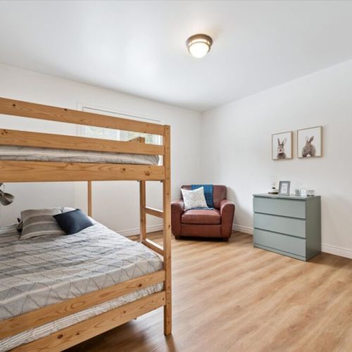 Versatile bunk room with plenty of open space for play, relaxation, or a quiet reading corner.