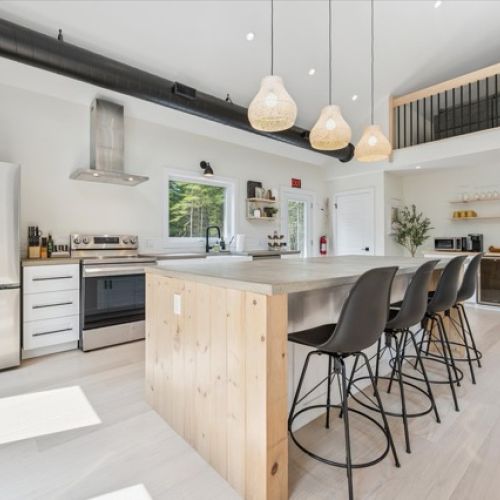 A spacious island, modern appliances, and forest views create a stylish, functional hub for meals and conversation.