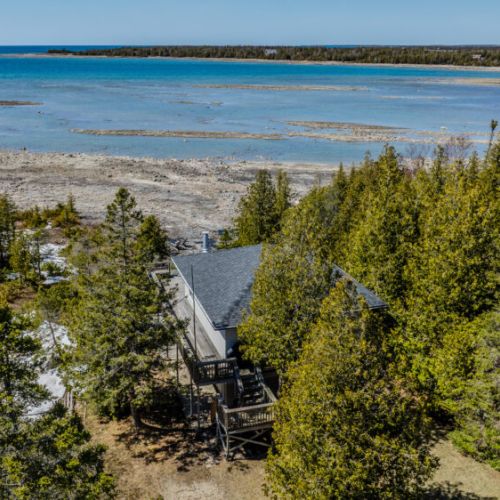 Private cottage retreat offering stunning panoramic views of turquoise waters and rocky shores, perfect for an unforgettable lakeside getaway.