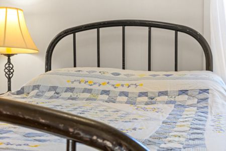 Cozy bedding and classic farmhouse character create a comfortable retreat for a restful night.