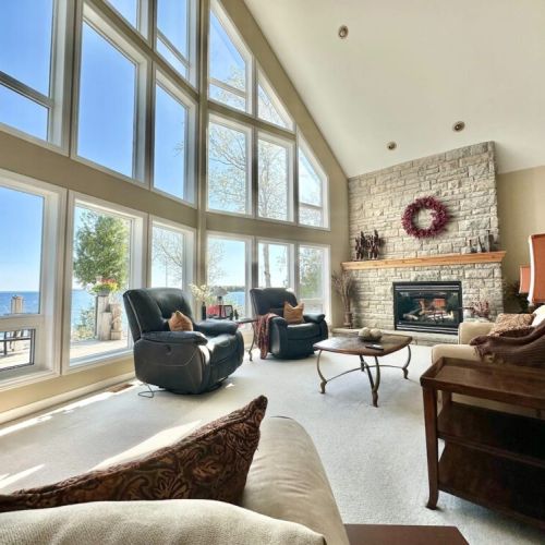 Gather beneath 24-foot vaulted ceilings, relax by the stone fireplace, and enjoy panoramic waterfront views through a wall of windows that brings the beauty of Tobermory indoors.