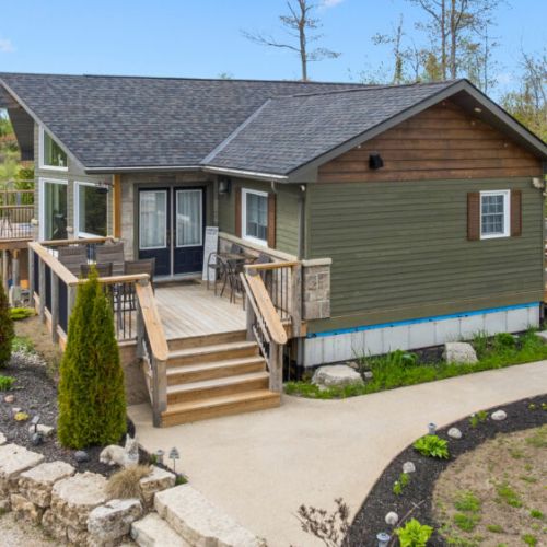The concrete pathway leading to both decks provides easy access to outdoor living spaces, allowing you to choose between soaking up the sun or relaxing in the shade throughout the day.