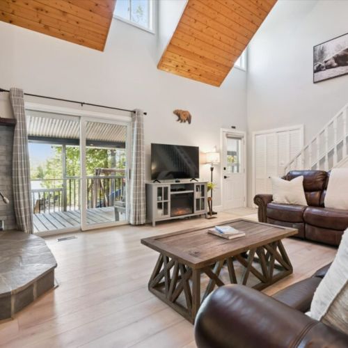 Relax in the spacious great room with vaulted ceilings, large TV, and easy access to the outdoor deck.